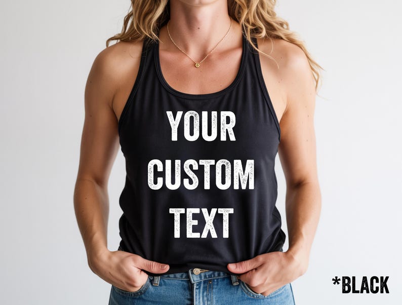 May include: Black racerback tank top with the words "YOUR CUSTOM TEXT" printed in white. The tank top is made of a soft material and is shown on a person. The text "*BLACK" is in the bottom right corner.