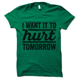 May include: Green t-shirt with the text "I want it to hurt tomorrow" in black.