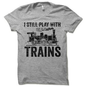 May include: A gray t-shirt with a black vintage-style illustration of a train and the text "I still play with trains".