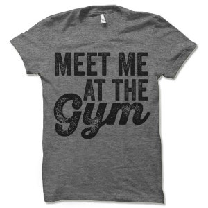 May include: Gray heather t-shirt with a black distressed graphic that says "Meet Me At The Gym".