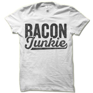 May include: White t-shirt with black text that reads "BACON Junkie" in a distressed font.