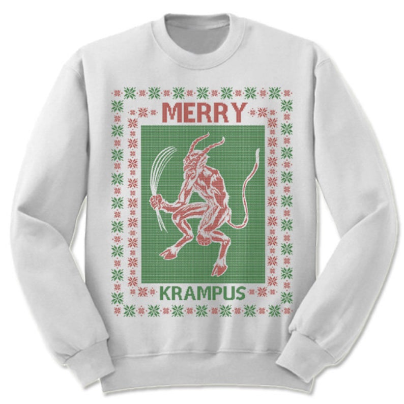 May include: White Christmas sweater with a red and green knit pattern. The sweater features a red illustration of Krampus, a mythical creature, with the text "Merry Krampus".