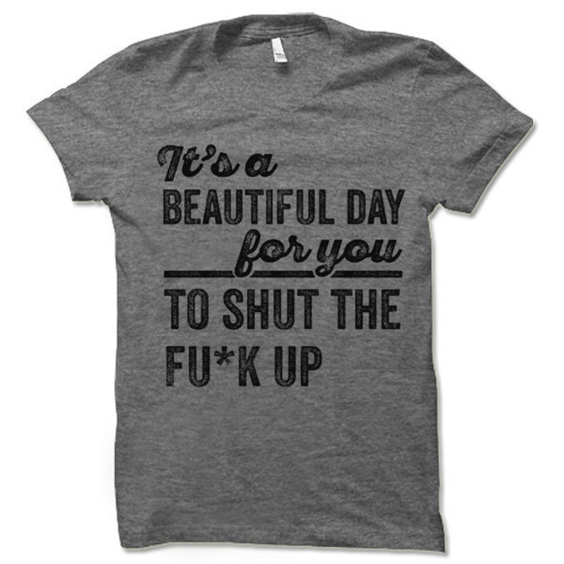 May include: A heather gray t-shirt with the phrase "It's a BEAUTIFUL DAY for you TO SHUT THE FU*K UP" printed in black. The shirt has a crew neck and short sleeves.