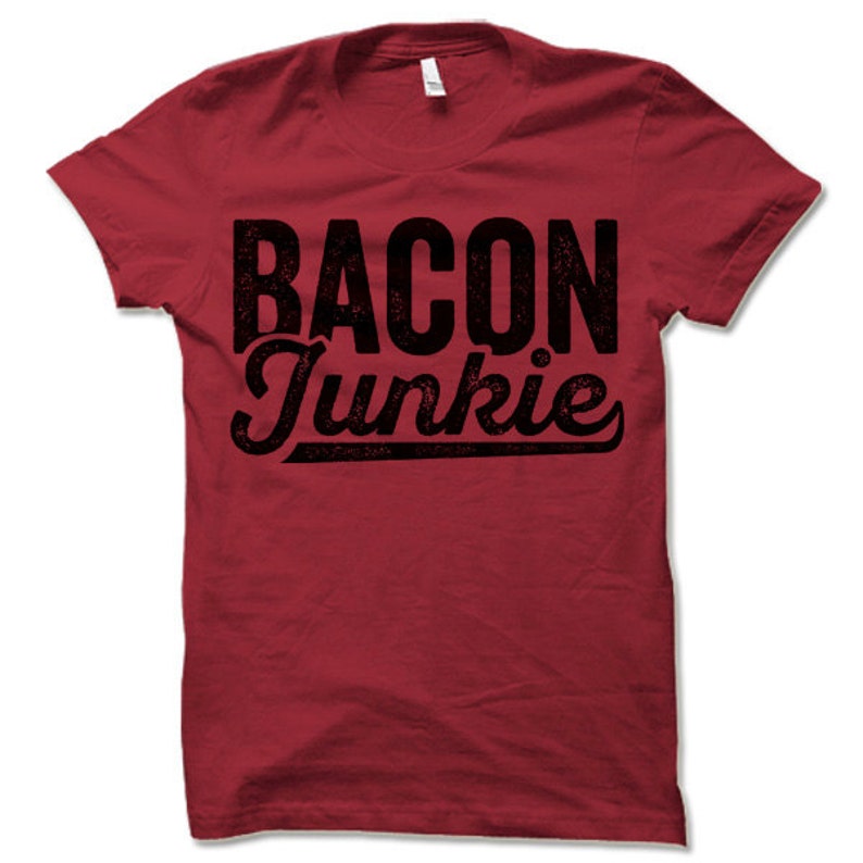 May include: Red t-shirt with black text that reads "BACON Junkie" in a distressed font.