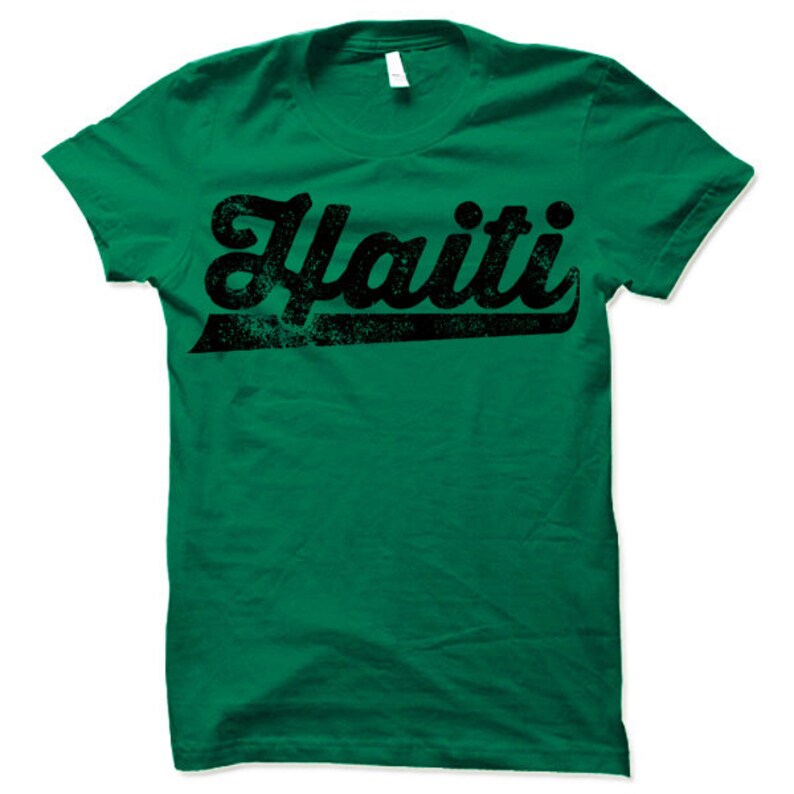 May include: A green t-shirt with a black distressed graphic that says "Haiti" in a retro font.