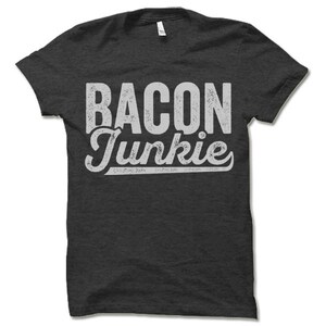 May include: A dark gray t-shirt with a white distressed graphic that says "Bacon Junkie".