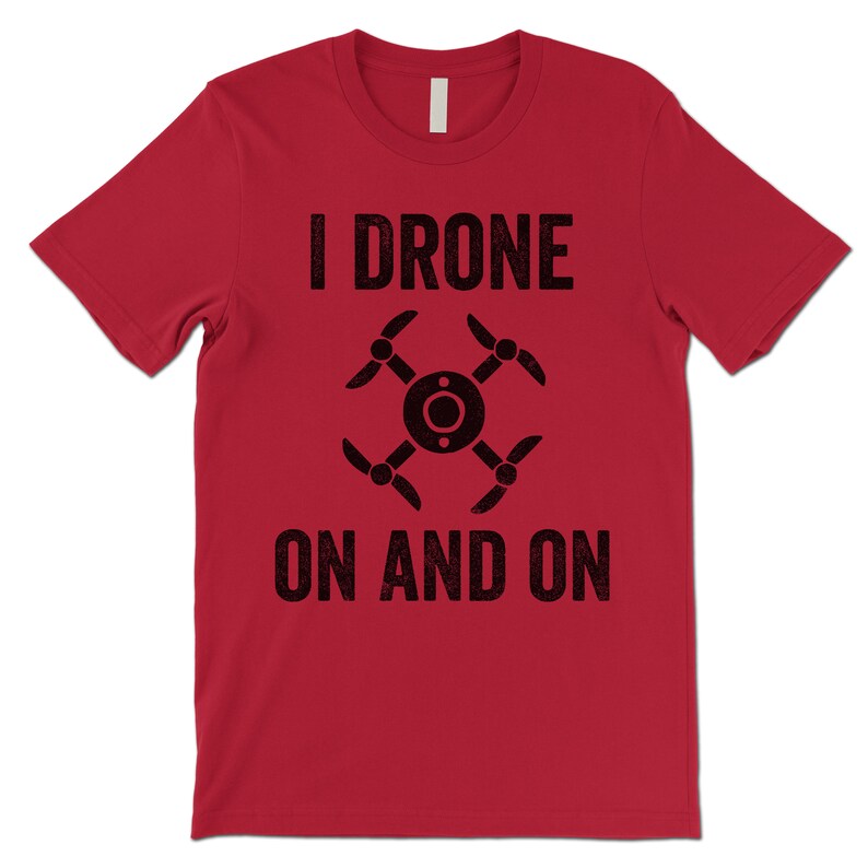 Op de afbeelding: Rood T-shirt met korte mouwen met een zwarte afbeelding van een drone en de tekst "I drone on and on".