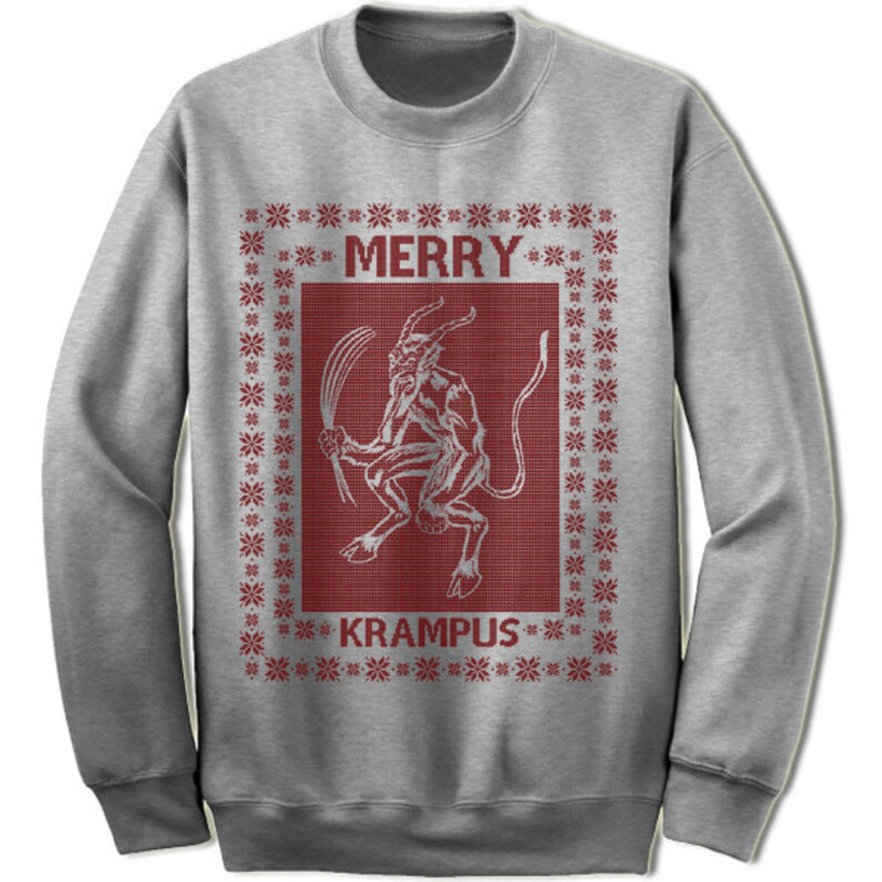 May include: A gray sweatshirt with a red and white Christmas-themed design. The design features a Krampus figure with the text "Merry Krampus".