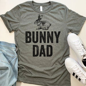 May include: A gray t-shirt with a black bunny rabbit graphic and the text "BUNNY DAD" printed on it.