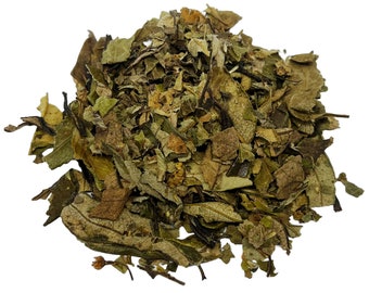 May include: A pile of dried, loose-leaf tea. The tea leaves are a mix of green, brown, and tan, with varying textures and sizes. The image is a close-up, showing the details of the dried leaves.