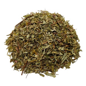 May include: A pile of dried green herbs with brown stems and leaves. The herbs are densely packed together, creating a textured appearance. The image is set against a plain white background.