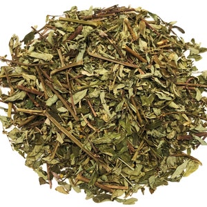 May include: A pile of dried, green herbs with brown stems and leaves. The herbs are densely packed, with a variety of shapes and sizes. The image is taken against a white background, highlighting the natural colors and textures of the herbs.