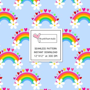 Op de afbeelding: Een naadloos patroon met kleurrijke regenbogen met witte madeliefjes en roze harten op een lichtblauwe achtergrond. De tekst "the pink heart studio" staat in een wit kader met een roze hart.