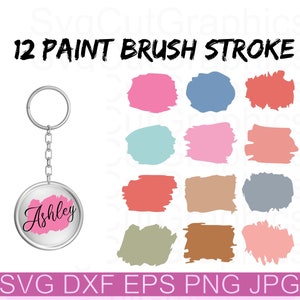May include: A silver keychain with a round charm that says "Ashley" in pink lettering. The image also includes 12 paint brush stroke designs in various colors, including pink, blue, red, green, and brown.