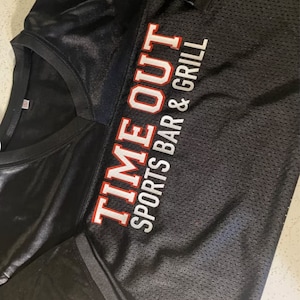May include: Black jersey with white and red text that reads "TIME OUT SPORTS BAR & GRILL"