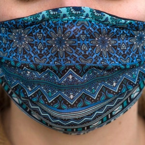 May include: A blue and black patterned face mask with a geometric design. The mask has a pleated design and is made of a soft, breathable fabric.