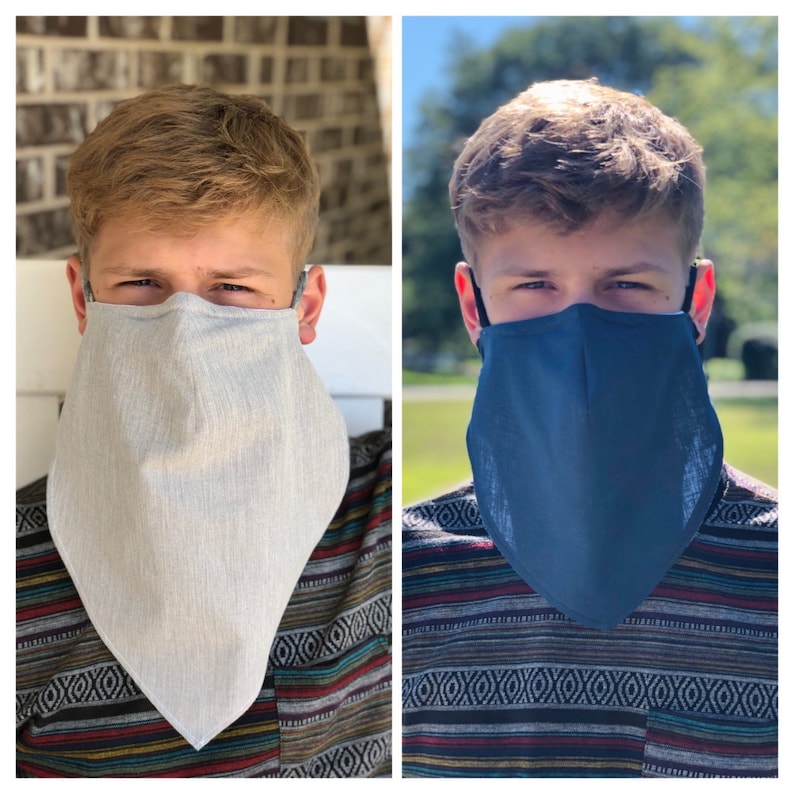 May include: Two face masks, one light gray and one navy blue, each designed to cover the nose and mouth, extending down to resemble a beard. The masks have adjustable ear loops for a secure fit. The background shows a person wearing the masks.
