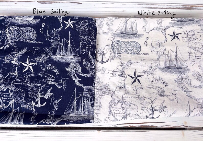 May include: Two nautical-themed fabrics, one navy blue and one white, are displayed. Both feature a map design with sailboats, anchors, and star accents. The text "Blue sailing" and "White sailing" are visible.
