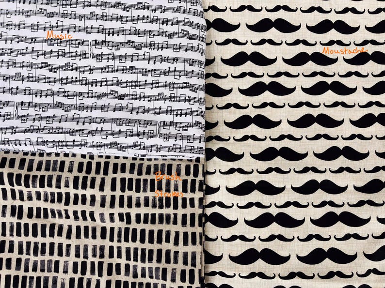 May include: A fabric panel featuring three distinct patterns. One section displays black musical notes on a white background with the word "Music". Another shows a repeating pattern of black mustaches on a beige background with the word "Moustache". The third section has a black and white abstract design with the words "Brush Strokes".