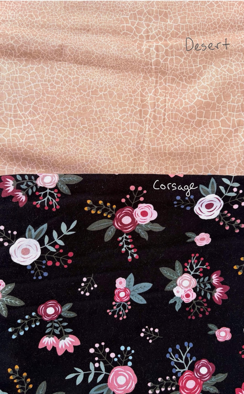 May include: A fabric sample with two contrasting designs. The top section has a tan, cracked pattern with the word "Desert". The bottom section features a black floral design with pink and white roses, green leaves, and the word "Corsage".