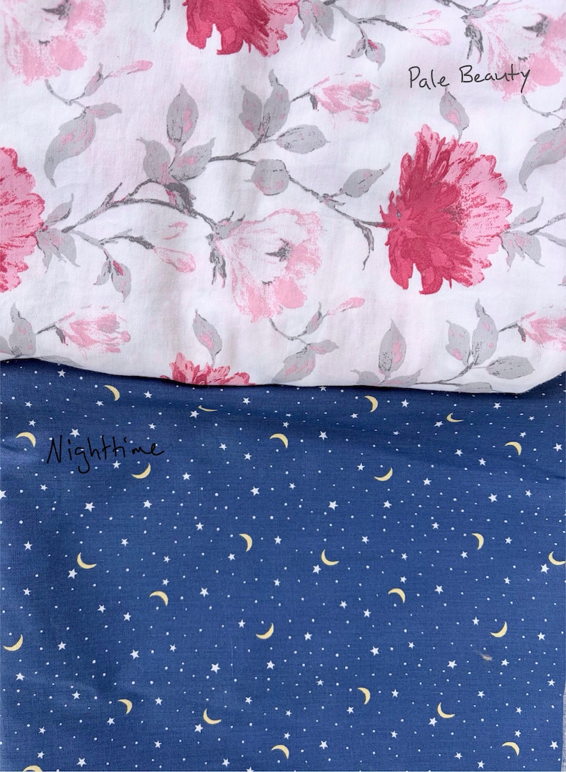 May include: Two fabric swatches. The top swatch is white with a floral pattern of pink and red flowers and gray leaves. The bottom swatch is navy blue with a pattern of white stars and yellow moons. Text on the top swatch says "Pale Beauty" and the bottom swatch says "Nighttime".