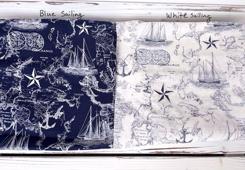 May include: Two fabrics with a nautical theme are shown, one navy blue and one white. Both have a map design with sailboats, anchors, and star accents. The text "Blue sailing" and "White sailing" are visible.