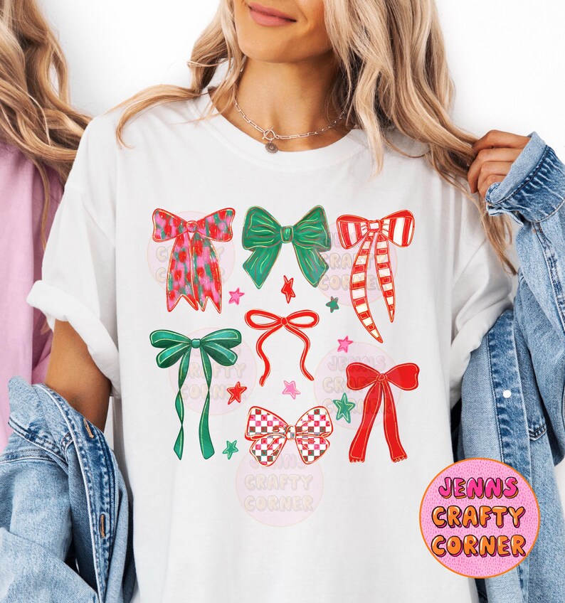 May include: White t-shirt featuring a collection of colorful bow illustrations. The bows are in various designs, including floral, striped, and checkered patterns, with green, red, and pink accents. The text "JENNS CRAFTY CORNER" is in a pink circle.