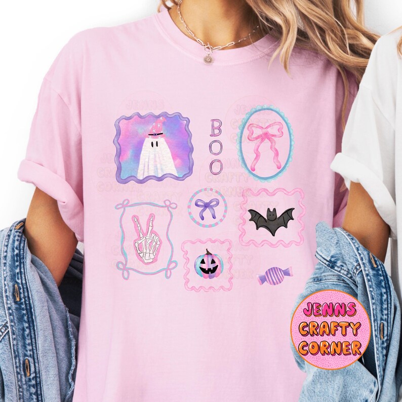 May include: A light pink t-shirt featuring several Halloween-themed illustrations in frames. The illustrations include a ghost, a bow, a bat, a peace sign skeleton hand, a pumpkin, and candy. The word "BOO" is vertically printed.