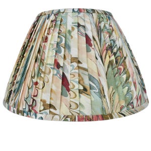 May include: A pleated lampshade with a floral pattern in shades of green, brown, pink, and white.