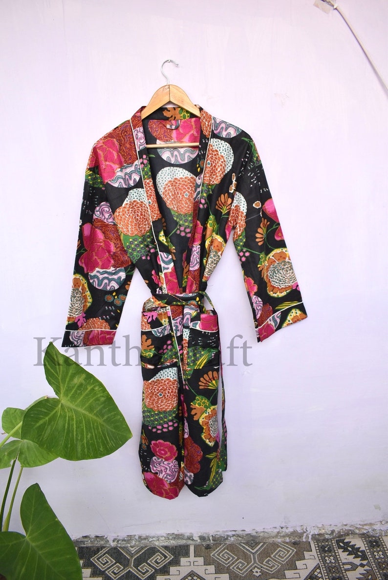 May include: A black floral print robe with a white trim and a tie belt. The robe has a long sleeve and a relaxed fit.