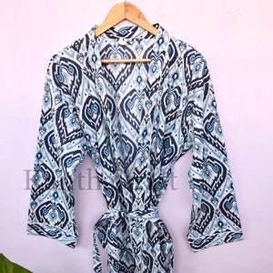 May include: A blue and white patterned cotton robe with a tie belt. The robe has a geometric design with a white background and blue accents.