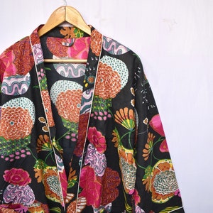 May include: A black kimono robe with a colorful floral print. The robe has a white trim and a tie closure.