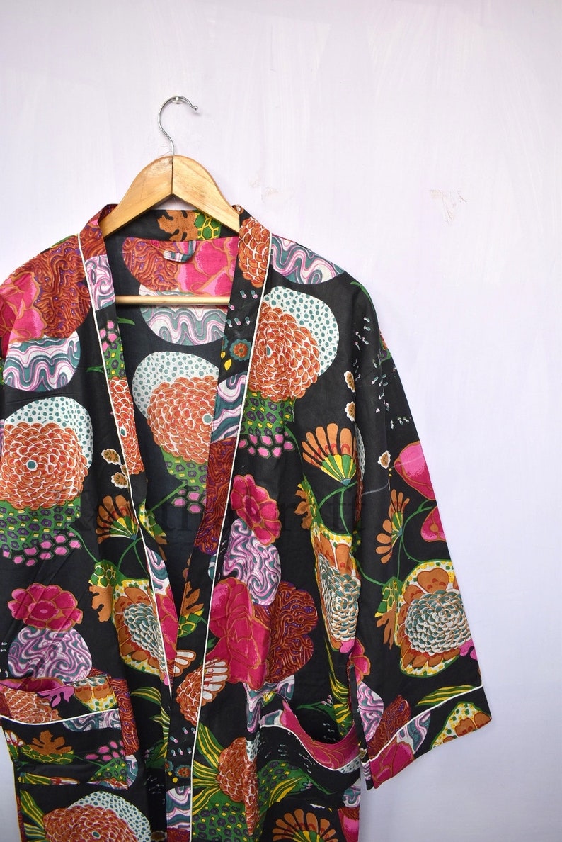 May include: A black kimono robe with a colorful floral print. The robe has a white trim and a tie closure.