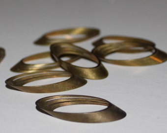 May include: A group of 10 brass rings, some stacked on top of each other, in various sizes and shapes. The rings are all oval-shaped and have a smooth, polished finish.
