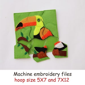 May include: A felt toucan puzzle with a green background. The toucan is yellow, orange, and black. There are two smaller birds, one brown and one red and white. The text "Machine embroidery files hoop size 5X7 and 7X12" is below the puzzle.