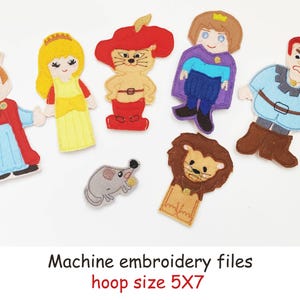 Peut inclure: Une collection de figurines de personnages en feutre coloré, dont un roi, une princesse, un chat, un prince et un lion. Les figurines sont de couleurs et de motifs variés. Le texte "Machine embroidery files" et "hoop size 5X7" sont également visibles.