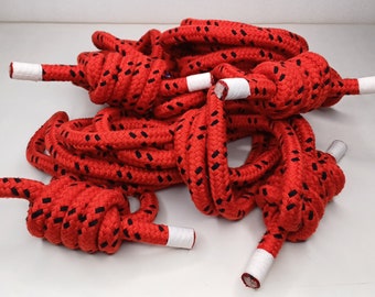 May include: Red and black rope with white tips. The rope is coiled and knotted.