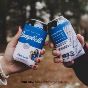 May include: Two blue and white can coolers with the Campbell's Soup logo and the text "Motor City Dan" and "Knee Cap Soup". One cooler shows the nutrition facts label.
