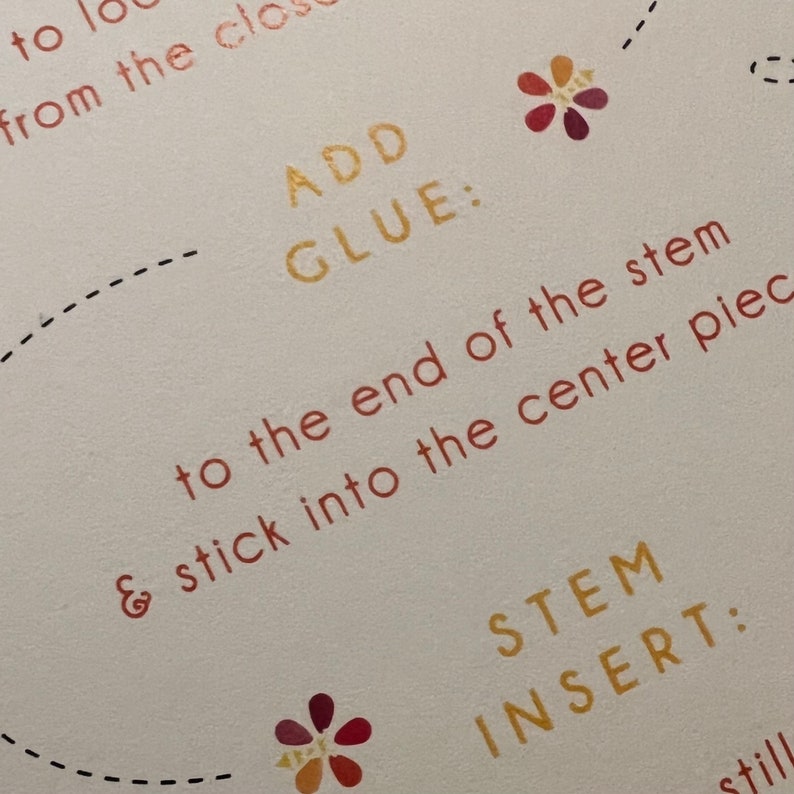 May include: Close-up of instructions for a craft project. The text reads "ADD GLUE: to the end of the stem & stick into the center piece" and "STEM INSERT:".