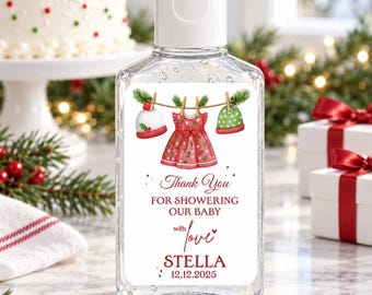 May include: A clear plastic hand sanitizer bottle with a white flip-top cap. The label features a clothesline with two knit hats and a red dress, with the text: Thank You FOR SHOWERING OUR BABY with love STELLA 12.12.2025 in red and black font.