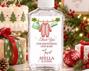 May include: A clear plastic hand sanitizer bottle with a white flip-top cap. The label features a watercolor illustration of a baby onesie and two hats hanging on a clothesline, with the text Thank You FOR SHOWERING OUR BABY with love STELLA 12.12.2025.