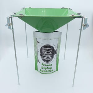 May include: A green metal funnel with a stand, used for freeze drying. The funnel is positioned over a silver pouch with the text "Freeze Drying Supplies".