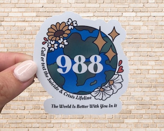 May include: A sticker with a blue and green globe with white flowers and gold stars. The text reads "Call or text the Suicide & Crisis Lifeline 988 The World Is Better With You In It."