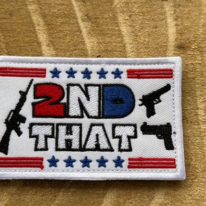 May include: Embroidered patch with the text "2ND THAT" in red, white, and blue, featuring images of a rifle and two handguns. The patch has a white border and stars and stripes design.