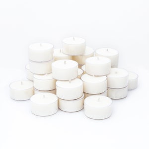 May include: A pile of white unscented tea light candles in clear plastic containers.