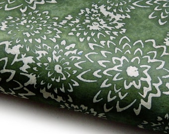 May include: Green wrapping paper with a white floral pattern. The flowers are stylized and have a slightly distressed look.