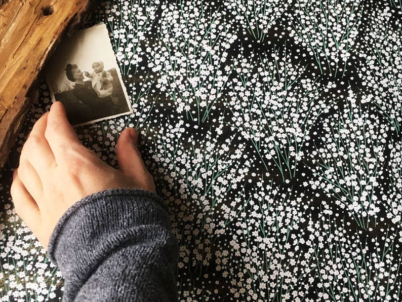 May include: A black and white photograph of two people, a woman and a child, with a floral pattern background.