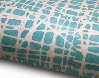 May include: A close-up of a light brown wrapping paper with a teal blue geometric pattern. The pattern is made up of irregular shapes that resemble a mosaic.