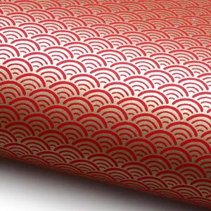 Könnte beinhalten: Rot-goldenes gemustertes Papier mit einem sich wiederholenden Wellenmuster. Das Papier hat einen metallisch goldenen Hintergrund mit roten wellenförmigen Mustern. Das Papier ist aufgerollt und zeigt das Muster im Detail.