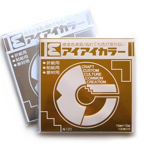 May include: Two packs of gold coloured paper. The front of the pack has the text "アイアイカラー" in Japanese. The text "CRAFT CUSTOM CULTURE COMMON CREATION" is also on the pack. The pack is labelled "No. 120" and "15cm x 15cm 100枚入り".
